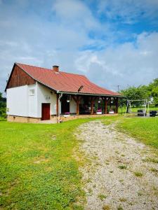 a building with a playground in front of a field at Őrségi Szajkó Vendégház in Kondorfa