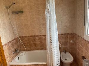 a bathroom with a white shower curtain next to a toilet at Casa Playa Fontela in San Pedro de Benquerencia +18 photos