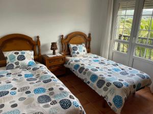 two beds sitting next to each other in a bedroom at Casa Playa Fontela in San Pedro de Benquerencia