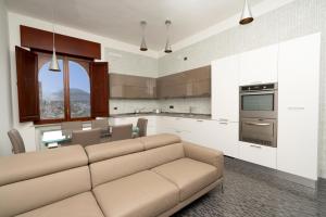 a living room with a couch and a kitchen at ca'santoro - locazioni turistiche in Agerola