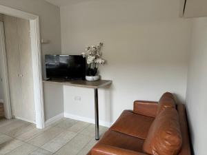 a living room with a couch and a table with a television at Small 25m2 Holiday Apartment with in walking distance of the University of Galway in Galway
