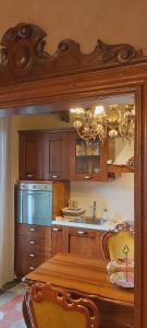 a kitchen with wooden cabinets and a table with chairs at Villa Costanza Appartamento con giardino in Magreglio +40 photos