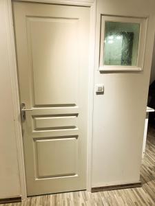 a white door with a window in a room at CHAMBRE et JARDIN Village au bord de l eau Cour et Garage privés in Marcilly-sur-Seine