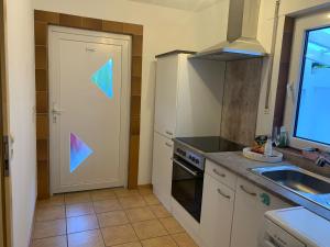 eine Küche mit einer Tür mit einem bunten geometrischen Muster darauf in der Unterkunft Charmanter Rückzugsort Parkplatz Küche eigener Eingang in Nümbrecht + 1 Foto