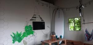 a room with a tv on a white wall at Chill House Flores in Flores