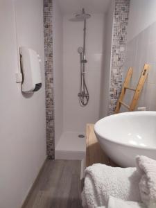 a bathroom with a white tub and a sink at Studio Cosy dans la maison d'enfance de Jean Giono in Manosque +3 photos