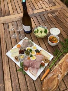 a table with a plate of food and a bottle of wine at Le jardin secret in Semur-en-Auxois
