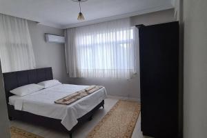 a bedroom with a bed and a large window at Deniz ve Doğa Manzaralı Daire Arsin-Trabzon in Arsin