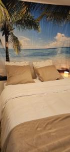 a bed with a view of the ocean and a palm tree at Mon Paris in Neuilly-sur-Seine