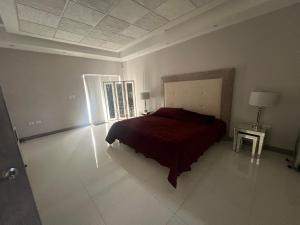 a bedroom with a bed with a red bedspread on it at Casa Concept Delicias in Delicias