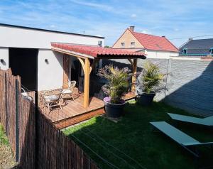 a backyard with a wooden deck with a chair at Pura Vida Spa - gîte avec spa extérieur couvert in Écaillon