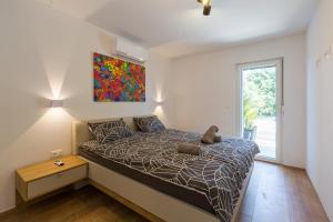 a bedroom with a bed and a painting on the wall at Villa Maša in Rovinj +31 photos