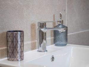 a bathroom sink with a faucet and a cup at Traditional Stone Villa 1 in Ellinikón +22 photos