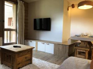 een woonkamer met een flatscreen-tv aan de muur bij Résidence Lauziere Dessus - La Lauzière Dessus 22 - Crève Coeur MAE-4544 in Valmorel