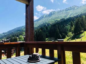 een tafel op een balkon met uitzicht op een berg bij Résidence Lauziere Dessus - La Lauzière Dessus 22 - Crève Coeur MAE-4544 in Valmorel +1 foto