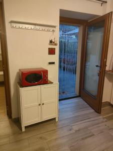 un microonde rosso appoggiato sopra un mobile di Maison Cocò ad Aosta Altre 13 foto