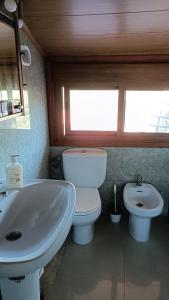 a bathroom with a white toilet and a sink at Casa Quintela in Ourense