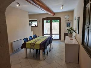 a dining room with a table and blue chairs at Partie de mas en campagne in Eyragues