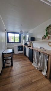 eine große Küche mit Holzboden und weißen Arbeitsplatten in der Unterkunft Grand studio Lille centre in Lille