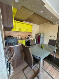 a kitchen with a table and chairs and yellow cabinets at Amazing View Apartment in Vratsa