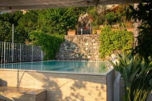 a swimming pool in a yard with a stone wall at La Casetta di Ceci in Vibonati