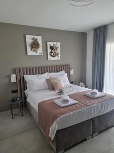 a bedroom with a large bed with two towels on it at Villa Klara in Privlaka