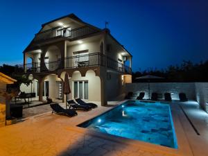 a villa with a swimming pool at night at Villa Marta in Mala Čista