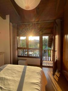 a bedroom with a bed and a large window at La Santina y su Balcón in Avilés