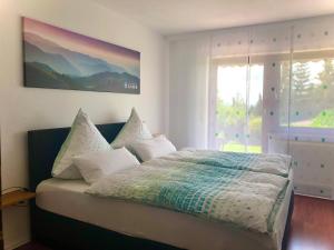 a bedroom with a bed and a large window at Apartment Kneer - Panoramic View & Private Garden near Black Forest & Lake Constance in Donaueschingen +37 photos