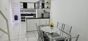 a kitchen with a table and chairs and a kitchen with a refrigerator at Apartamento Praça da Bíblia in Bom Jesus da Lapa