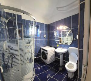 a blue tiled bathroom with a toilet and a sink at Casa Melcilor in Mangalia
