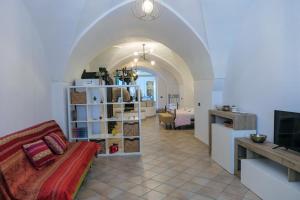 a living room with a couch and a room with a kitchen at FRANTOIO NONNA VALERIA in Diso