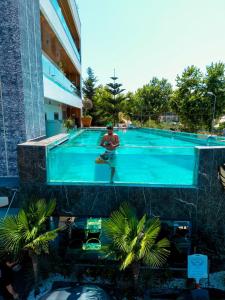 a man is sitting in a swimming pool at Ilio Boutique Hotel in Ksamil