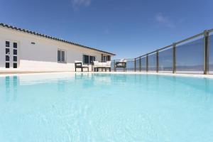 einem großen Wasserbecken vor einem Gebäude in der Unterkunft Villa de lujo Concordia Piscina climatizada y excelentes vistas in Puerto de la Cruz
