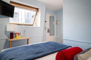 a bedroom with a blue bed and a window at Hotel de Saint-Germain in Paris