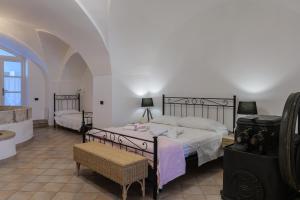 a large bedroom with two beds and a chair at FRANTOIO NONNA VALERIA in Diso