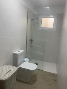 a white bathroom with a toilet and a shower at Apartamento Chapaleta in Caleta de Sebo