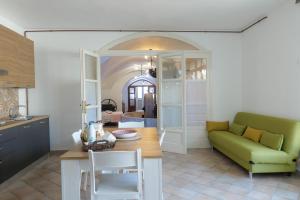 a kitchen with a table and a green couch at FRANTOIO NONNA VALERIA in Diso