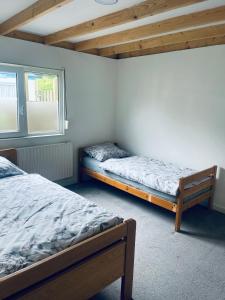 een slaapkamer met twee bedden en een raam bij Mooie chalet met grote tuin dichtbij Amsterdam in Opmeer