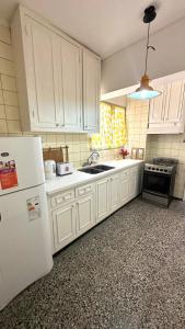 a kitchen with white cabinets and a white refrigerator at Departamento España in Mendoza +16 photos