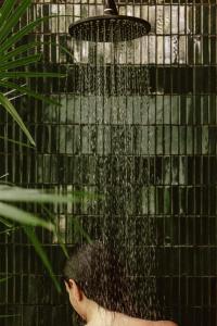 a person is under a shower with water at Boca de Agua Bacalar in Bacalar +51 photos