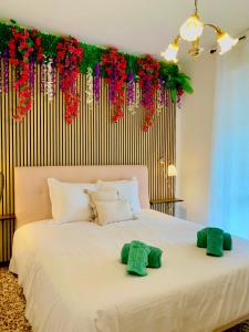 a bedroom with a white bed with red flowers on the wall at Spacious, minimalist, chic "Maison de Fleurs" in Malgrate