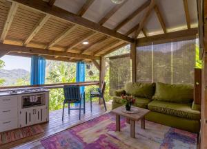 a living room with a green couch and a table at Bauhinia- in Roseau