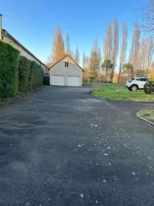 an empty parking lot with a white garage at Kindia au Mans Maison 7pers, 3km circuit des 24H in Arnage