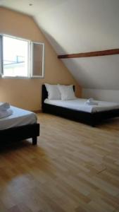 a room with two beds and a window at Kindia au Mans Maison 7pers, 3km circuit des 24H in Arnage