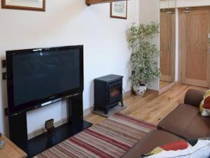 The Granary Thirsk Luxury Holiday Cottage Barn في ثيرسك: غرفة معيشة مع تلفزيون بشاشة مسطحة وموقد +12 صورة