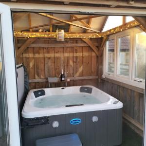 The Granary Thirsk Luxury Holiday Cottage Barn في ثيرسك: حوض جاكوزي في كابينة مع أضواء على السقف