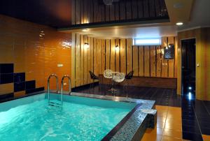 a jacuzzi tub in a room with a table and chairs at Broliu Vila in Druskininkai