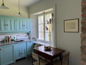 a kitchen with blue cabinets and a wooden table at Studio apartament, Dwor Kuflew in Kuflew