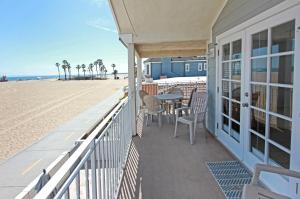 a balcony with a table and chairs on the beach at 1404 W Oceanfront B in Newport Beach